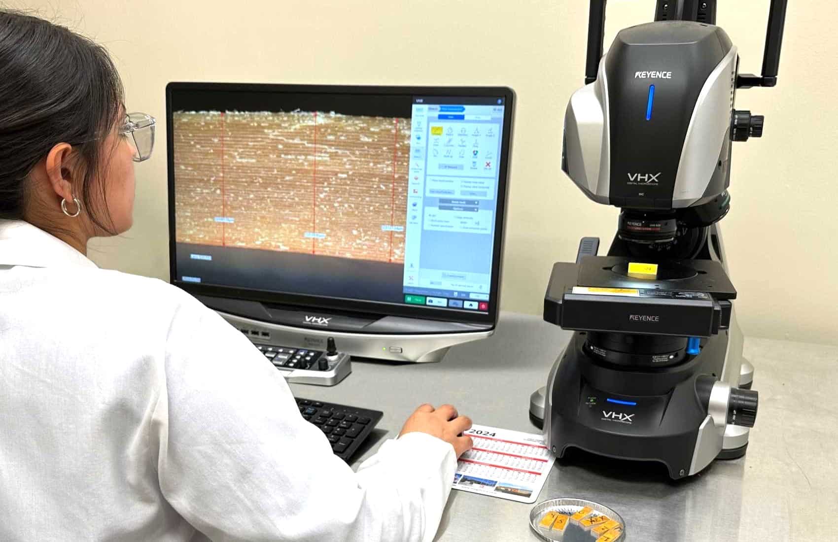 R&D technician examining honeycomb core through a microscope